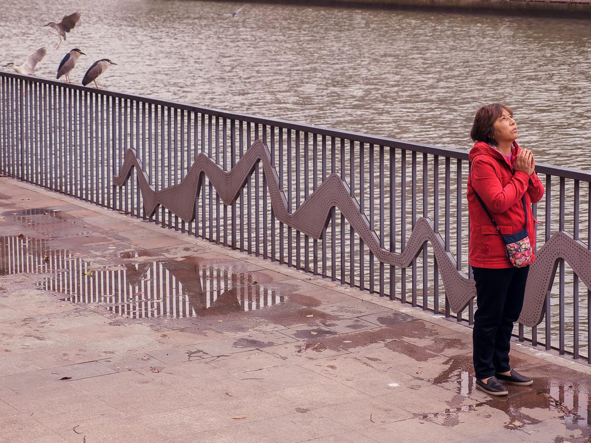 a woman prays by the river