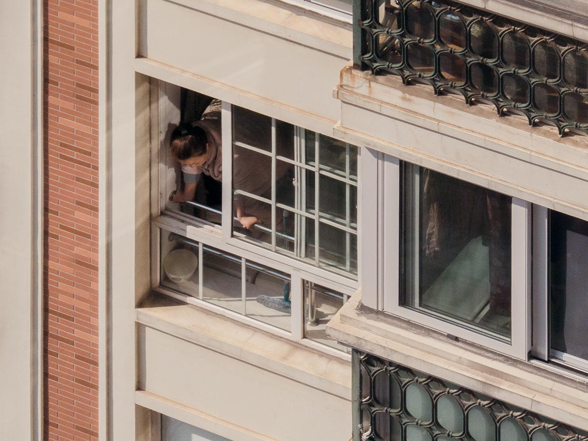 a woman looks out the window to see what's going on